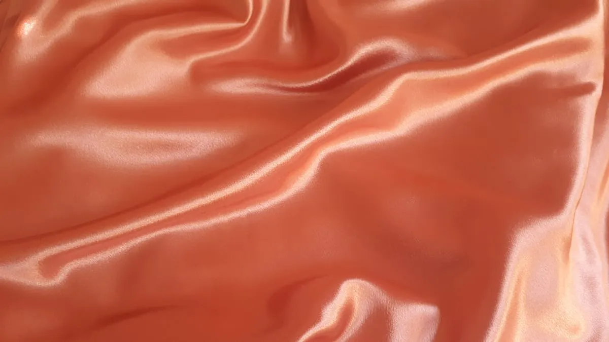 Coral satin textile with glossy ripples
