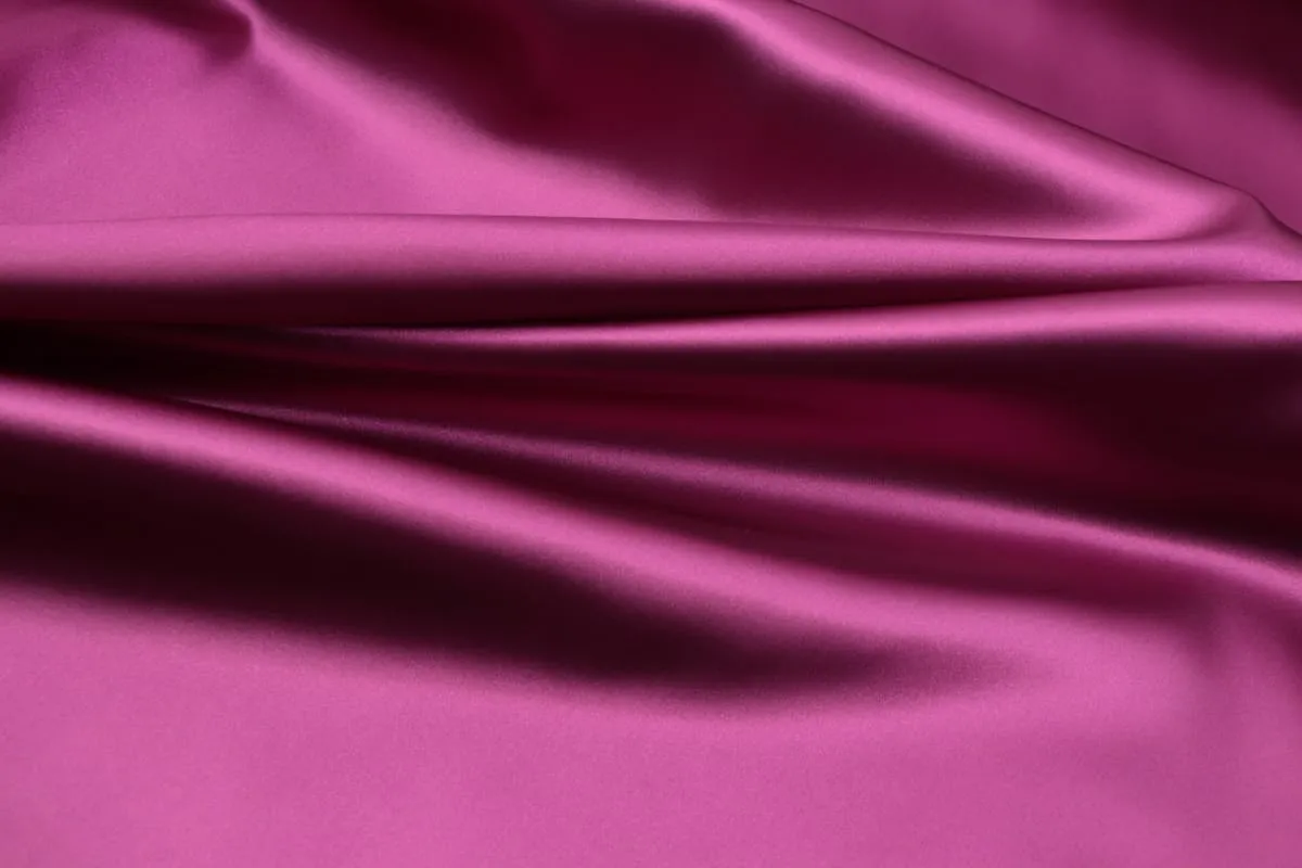 Plum satin textile laid in a clean horizontal fold