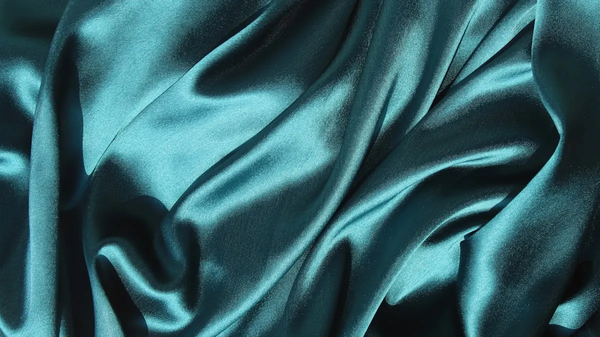 Teal satin fabric used as the atelier brand mark